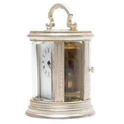 20th century-Silver plated 8-day timepiece carriage clock in an oval case, enamel dial with Roman numerals, minute track and steel moon hands, with an oval viewing class to the lever platform escapement. With key.