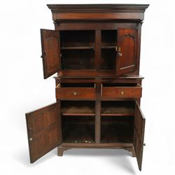 Early 19th century Welsh oak kitchen cupboard, the projecting cornice with twin cupboard doors, the rectangular base over two frieze drawers and panelled cupboard doors, raised on bracket feet, with fielded and arched panel variants to front and sides