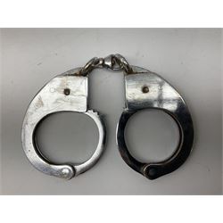 British Transport Police Custodian helmet with Queen's Crown plate; Hiatt & Co ebonised hardwood patrol truncheon; and pair of Hiatts 1960 hand-cuffs (3)