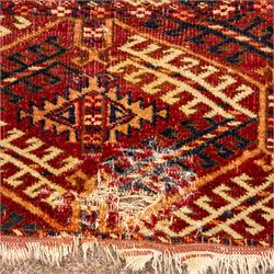 Vintage Bokhara hand-knotted rug, madder field woven in rows of octagonal Tekke guls arranged in vertical columns, each enclosing angular cruciform devices and tribal motifs, divided by narrow indigo lines, within multiple geometric borders incorporating stepped lozenges and latch hook devices, with cotton fringe ends 