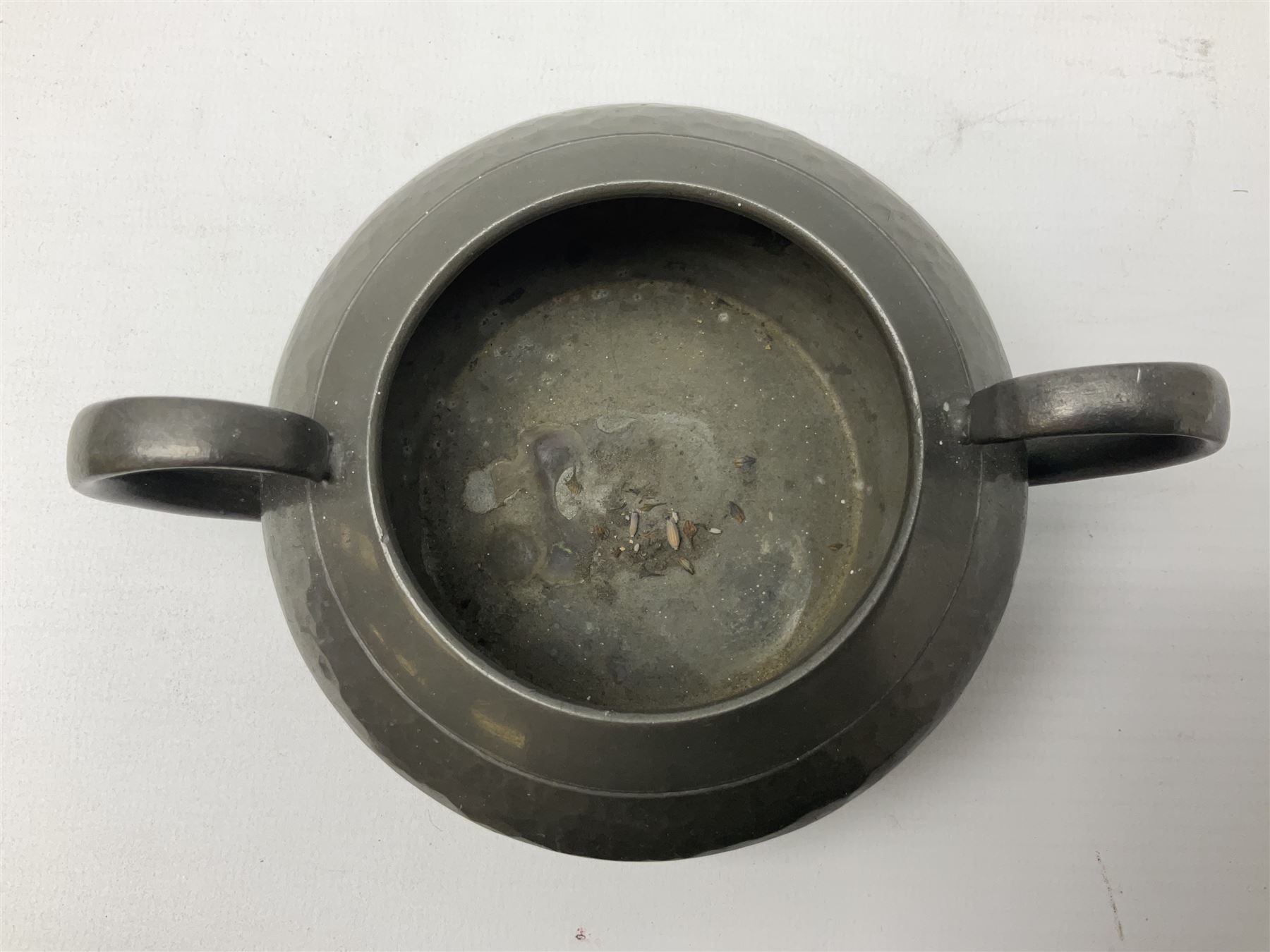 Liberty & Co Tudric pewter three piece tea service, comprising teapot with woven reed handle, twin handled open sucrier, and milk jug, each of squat form with planished finish, each impressed beneath Tudric Pewter Ware 01537 Made in England, together with a matched unmarked tray