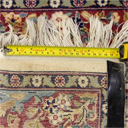 Two Central Persian rugs, ivory ground with a symmetrical foliate and floral design around a shaped cartouche medallion with a red floral and bird motif border with contrasting guard stripes, 142x76cm, Central Persian Kashan rug, crimson central field with a floral and foliate design with a stylized rosette medallion incorporating palmettes and scrolling vine work, enclosed by a dark navy border and multiple guard stripes, 117x68cm, (2)
