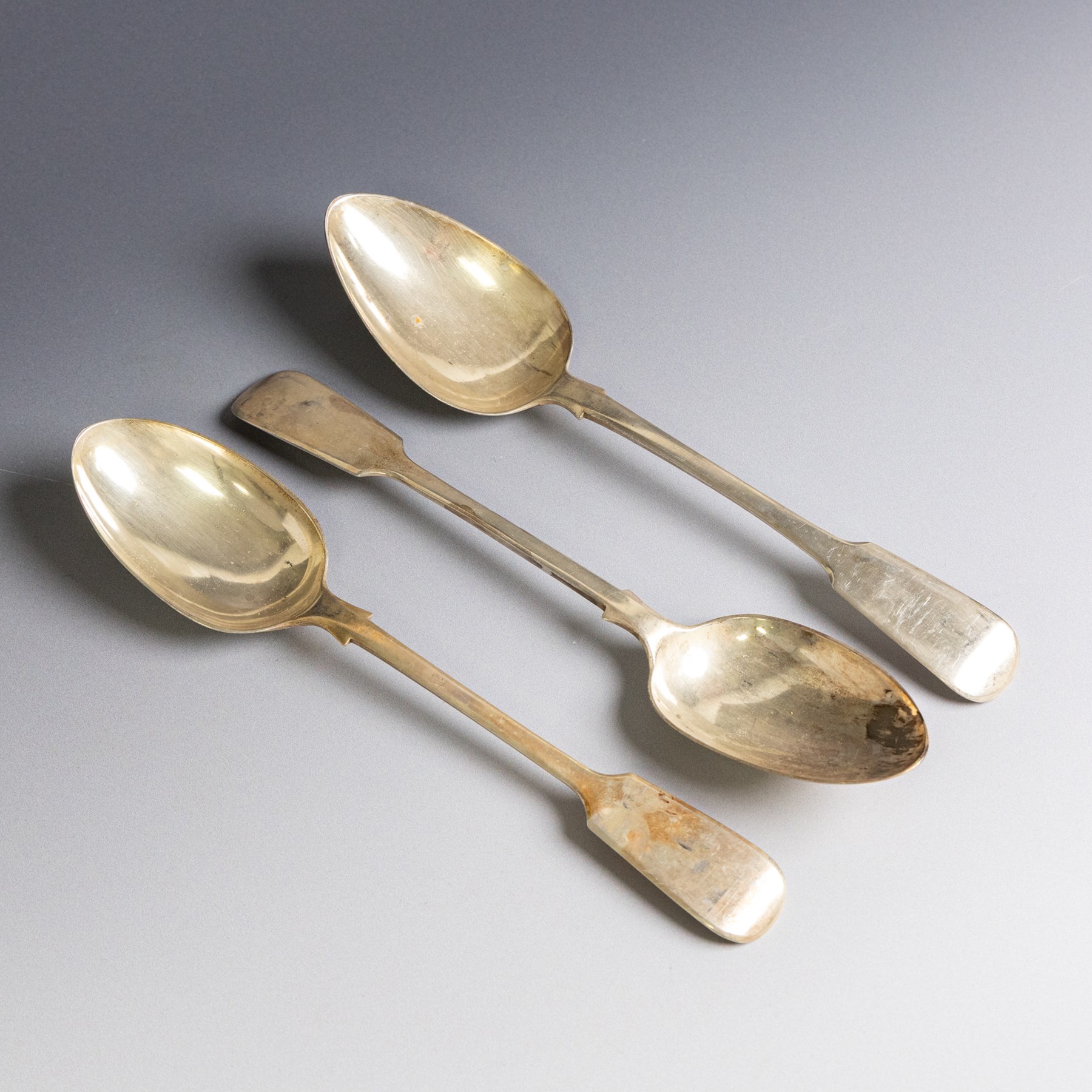 Three Fiddle pattern table spoons, comprising an Edwardian pair hallmarked Robert Stebbings, London 1908, and a single George IV example, hallmarked James Beebe, London 1823