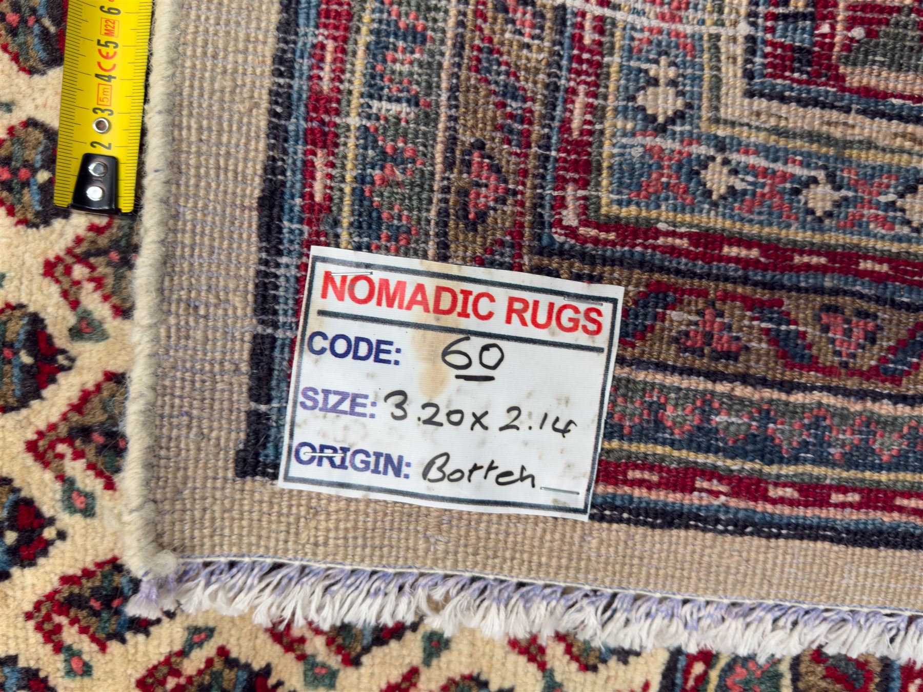 Northwestern Persian Bottehmir hand-knotted rug, ivory field with an all-over design of boteh motifs arranged in diagonal rows within multiple borders and a primary madder red field with stylized vine and flowerhead motifs, 320cm x 214cm 