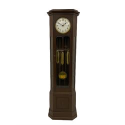 A mid-20th century weight driven floor standing clock in an oak case with canted glazed panels, full length glazed trunk door on a rectangular plinth with applied double skirting, white enamel dial with a gilt slip, upright Arabic’ numerals, minute markers, quarter hour Arabic’s and steel spade hands, with a three-train weight driven Westminster chiming movement chiming on two sets of gong rods.
With pendulum and weights.

