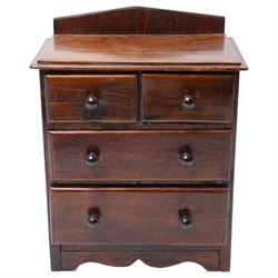 Miniature stained pine chest of two long and two short drawers above a shaped apron W28cm
