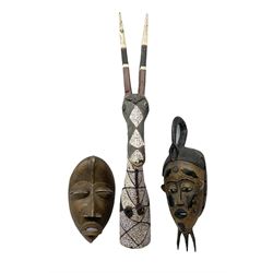 Two carved african spirit masks, together with a carved animal mask, painted and with beaded detail, largest example H86.5cm  