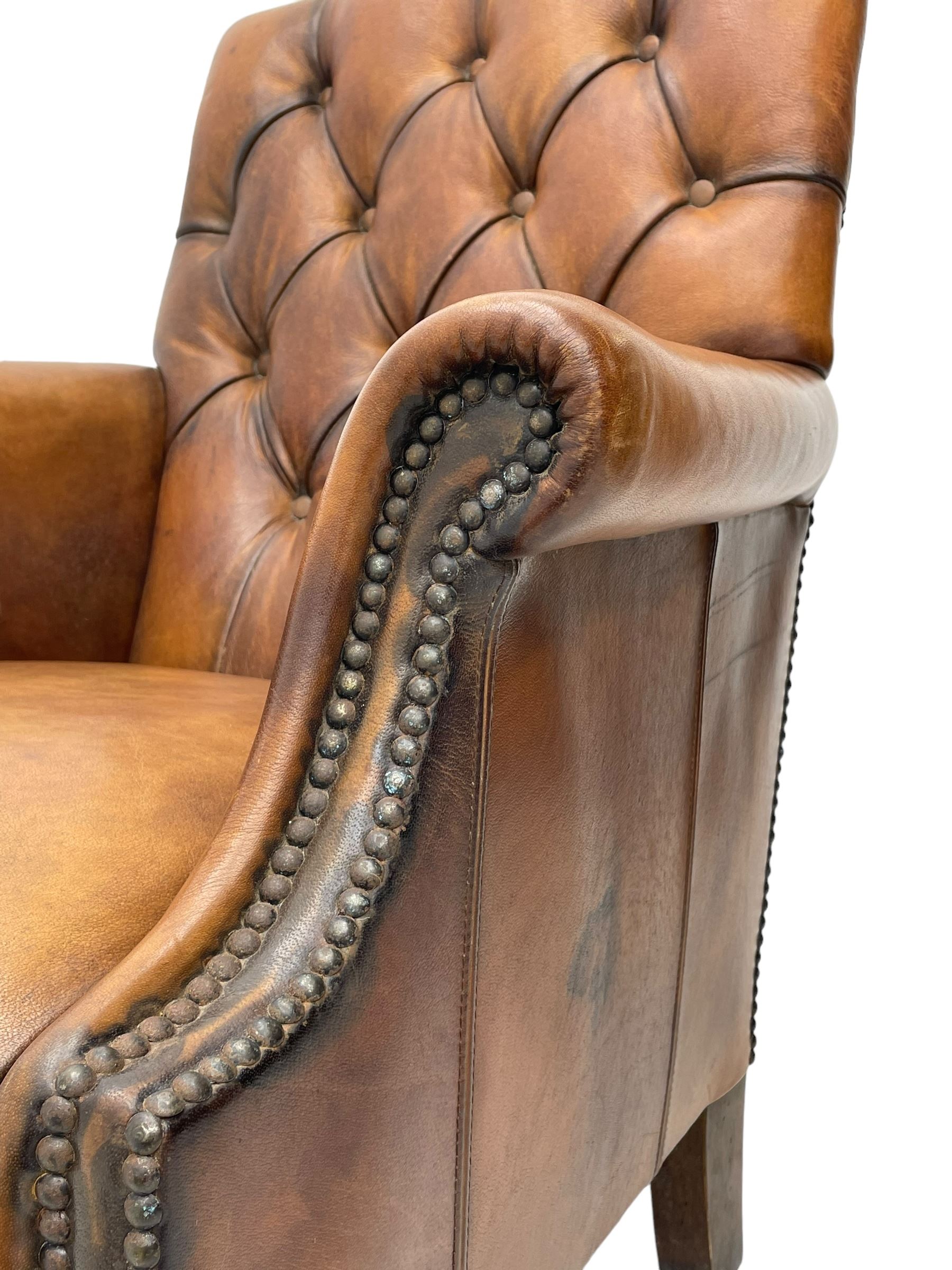 Laura Ashley - hardwood-framed armchair, traditional shape with arched cresting rail over rolled arms, upholstered in buttoned brown leather with studded work, on turned front feet (W76cm, W95cm, D84cm); together with matching rectangular footstool (53cm x 34cm, H29cm)