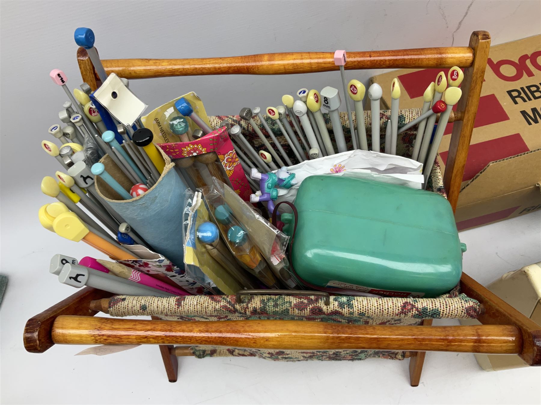  Brother cased knitting machine model KH-890 together with Brother Ribbing attachment model KH-850, knitting machine yarn cones in assorted colours, selection of knitting patterns etc