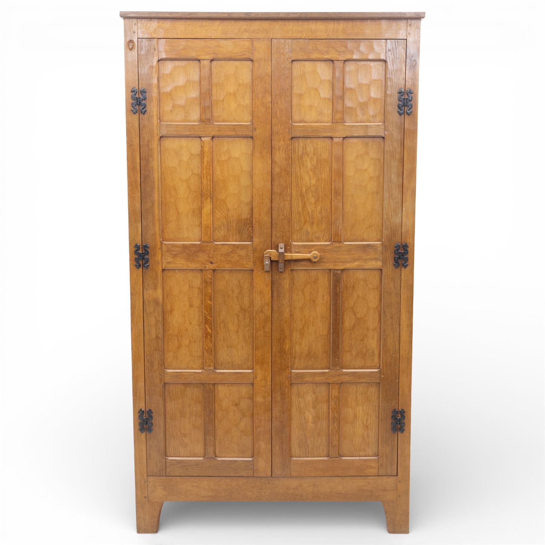 Acornman - oak adzed panelled double wardrobe, with wrought iron hinges and carved oak latch revealing a single clothes rail, with signature carved acorn to top left, by the workshop of Alan Grainger, Brandsby