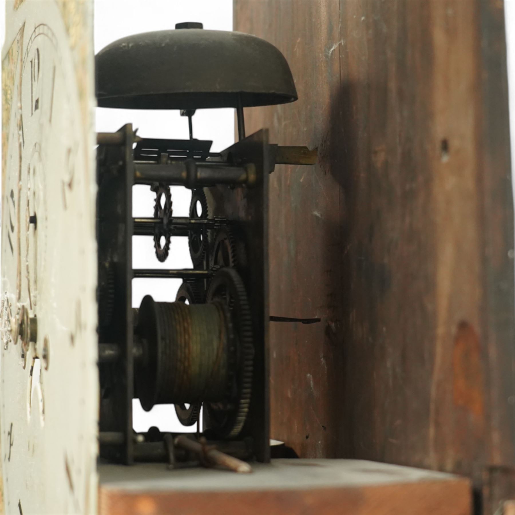 19th century-Oak and Mahogany 8-day longcase clock c 1820 (maker indistinct) with an open carved swan necked pediment and central finial, hood door flanked by turned pilasters, trunk with canted corners and a plain rectangular door, plinth with crossbanding and raised on bracket feet, painted dial with tumbling Arabic's, floral spandrels and conforming decoration to the arch, with a seconds hand, date aperture and brass stamped hands, dial pinned to a rack striking movement striking the hours on a bell. With weights & pendulum.
