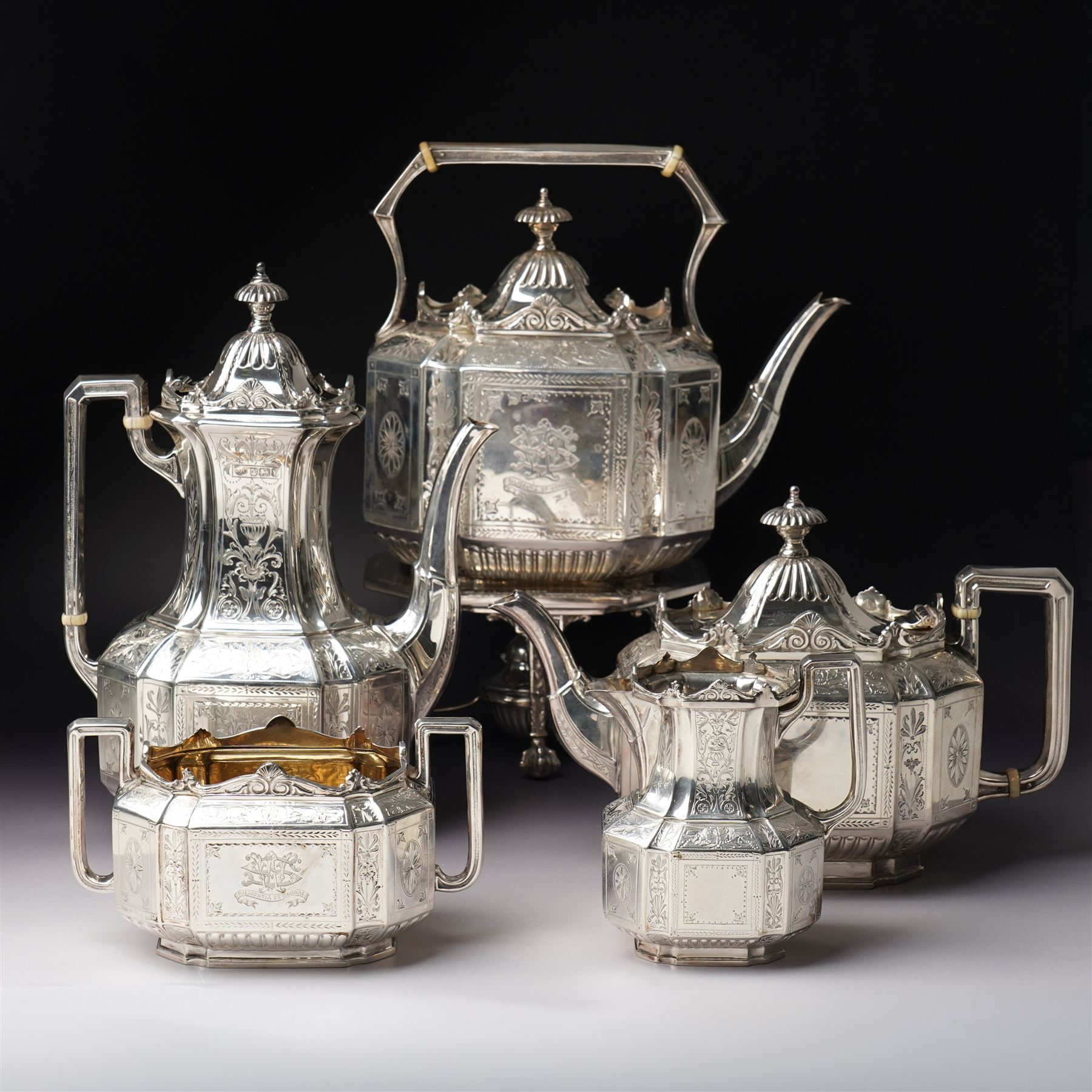 Victorian silver tea and coffee set engraved with classical urns, oval paterae and scrolling foliage, monogram and 'Diligentia et Honore' comprising teapot, tea kettle on spirit heater stand, coffee pot, two handled sugar bowl and cream jug Sheffield 1891 Maker John Round & Son Ltd