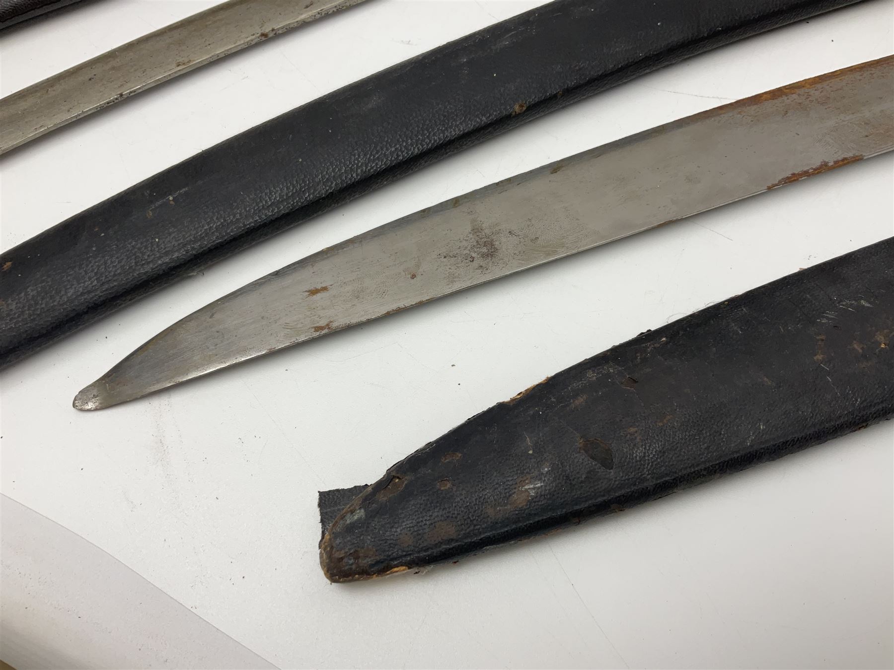 Four Indian tulwar swords; three with cast brass hilts and one with iron hilt; longest blade 81cm; all with scabbards (4)
