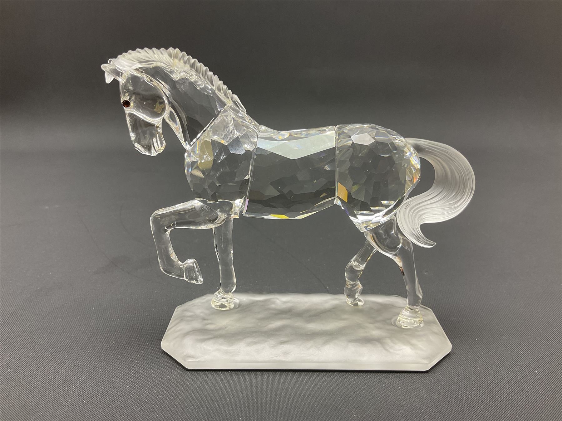 Five Swarovski Crystal horses, comprising stallion, rearing horse, pair of horses playing and Arabian stallion, each with frosted manes and tails, together with a small Swarovski Crystal galloping horse, the mane, tail and base with smoky tint