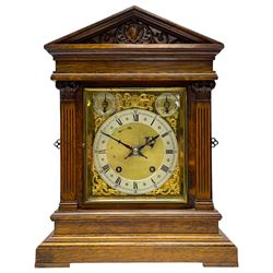 Winterhalder & Hofmeier- German 8-day oak cased mantle clock, in an architectural styled case with a gable pediment and recessed carving to the tympanum, square brass dial flanked by carved reeded pilasters and capitals, with open carved silk backed sound frets on a shaped plinth with padded feet, brass dial with cast spandrels and silvered chapter, Roman numerals, minute track and stylised gothic hands, conforming chime/silent and pendulum regulation dials, twin train going barrel movement with quarter-hour striking on two coiled gongs and the hours on one.
With pendulum.