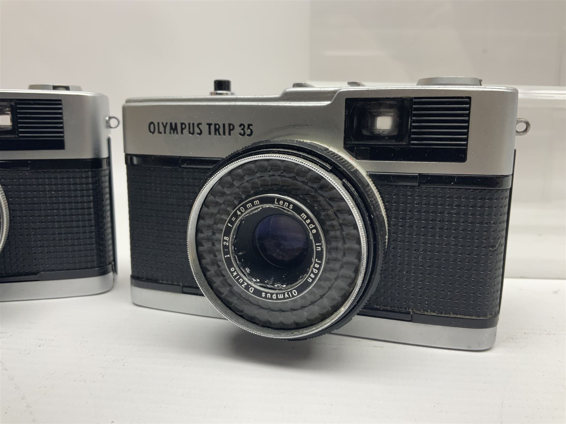 Olympus Pen-EE camera, serial no 415299, with Olympus D.Zuiko 1:3.5 f=2.8cm lens, together with four Olympus Trip 35 cameras, serial nos 4759245, 4257589, 1847727 and 5387611, each with Olympus D. Zuiko 1:28 f=40mm lenses