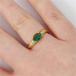 14ct gold emerald and diamond three stone ring, oval cut emerald with a round brilliant cut diamond set either side, to a wave design shank