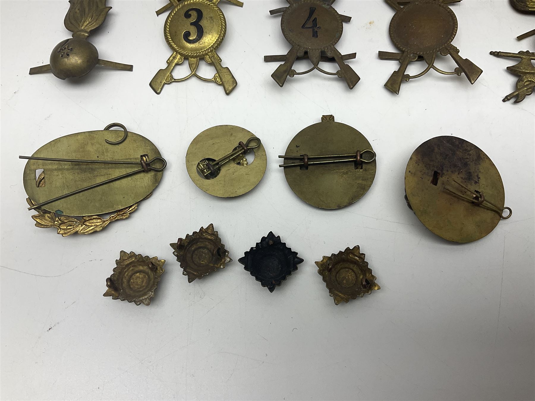 Over thirty British and Continental military metal badges; together with quantity of shoulder titles, collar dogs, rank pips, uniform buttons etc