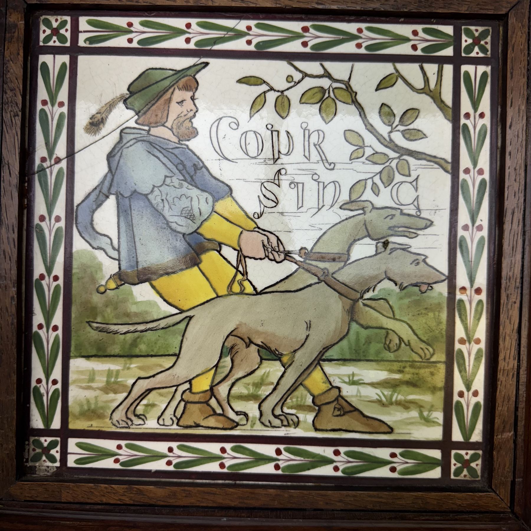 Pair of Victorian tiles, the first depicting a man with a pair of hunting dogs, the other a woman playing croquet each within a foliate boarder, within oak frames, H25cm, 