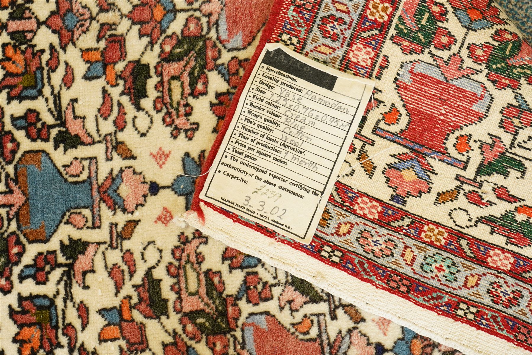 Iranian Persian style rug, repeated stylised vase and floral motifs arranged symmetrically across a ivory field, framed by red main border