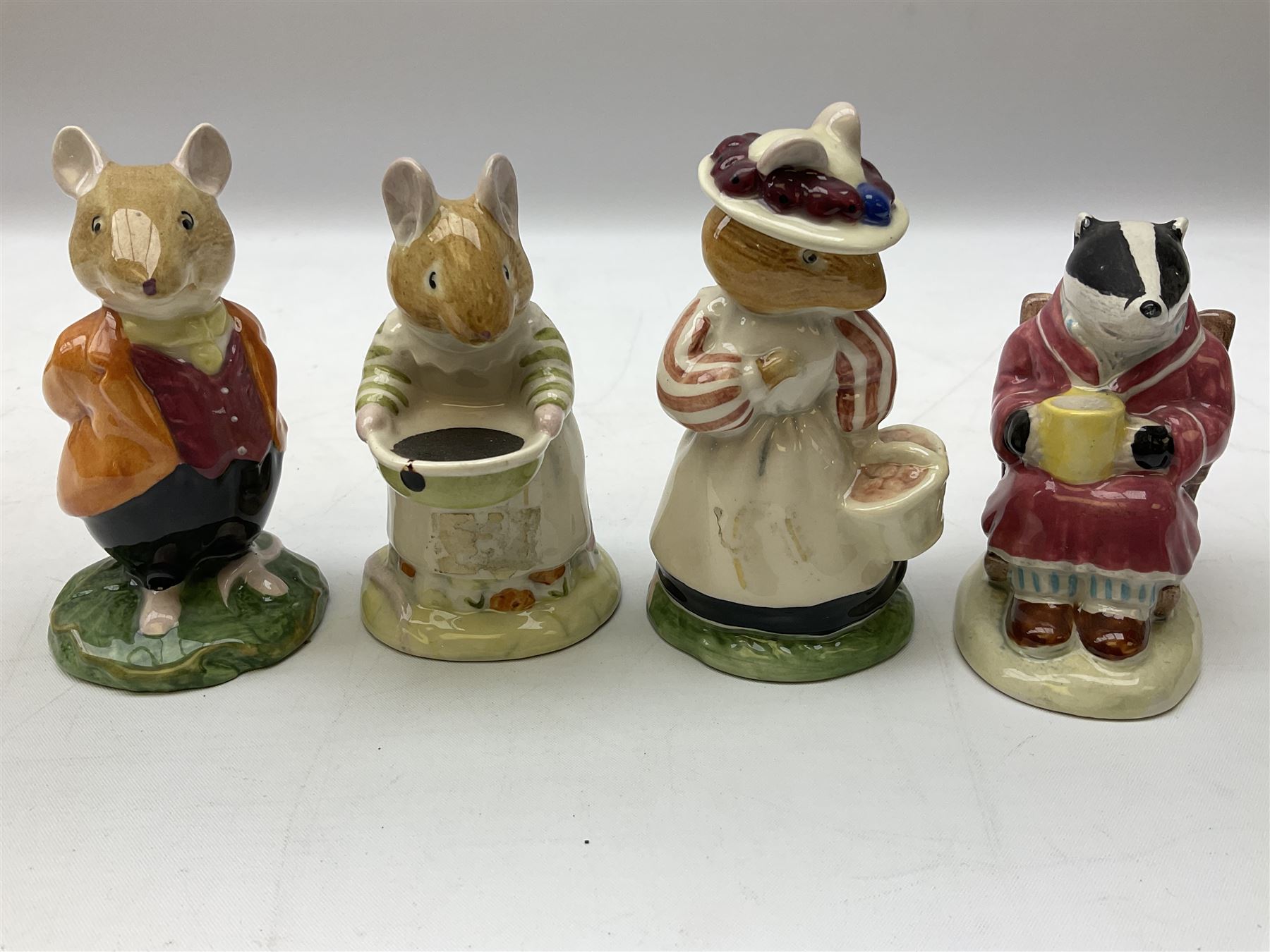 Fifteen Royal Doulton Brambly Hedge figures, comprising Wilfred Toadflax, Dusty Dogwood, Mrs Toadflax, Mr Apple, Primrose Woodmouse, Lord Woodmouse, Poppy Everbright, two Lady Woodmouse, two Old Mrs Everbright, Mr Toadflax, Mrs Apple, Santa Bunnykins and Bunnykins, together with three Royal Albert Wind in the Willows figures comprising Ratty, Badger and Mole, all with printed marks beneath (18)