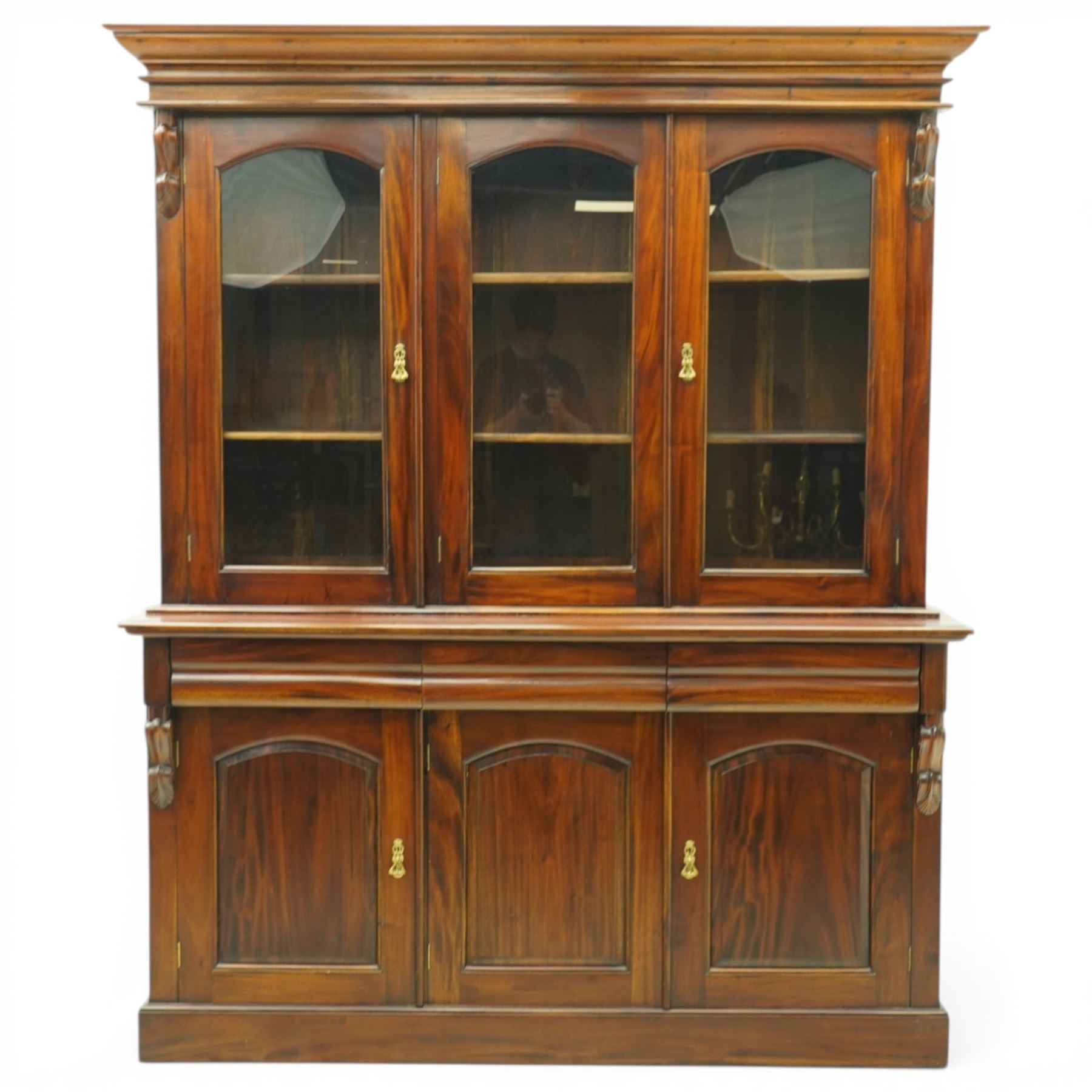 Victorian revival hardwood dresser cabinet, projecting moulded cornice above three glazed doors with shaped tops enclosing shelves, moulded top over three drawers and three panelled cupboard doors, flanked by applied carved brackets, on plinth base