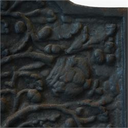 Early 20th century cast iron fireback, arched rectangular form cast in relief with a fruiting oak tree issuing acorns and leaves, surmounted by a crown, the trunk encircled by a ribbon tied cartouche with trailing scrollwork and foliate decoration, within a plain raised border