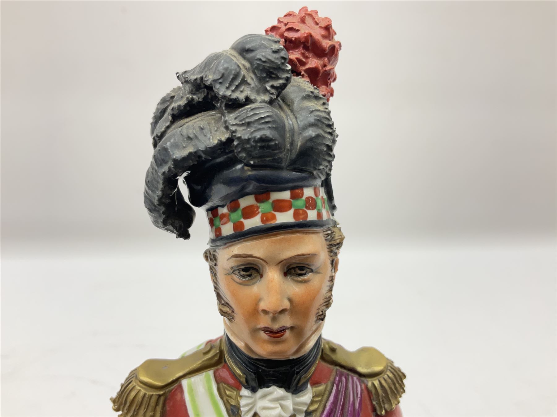 Sitzendorf figure, The Black Watch officer, c1815 standing to attention in full dress with sword, blue factory marks beneath, H28cm