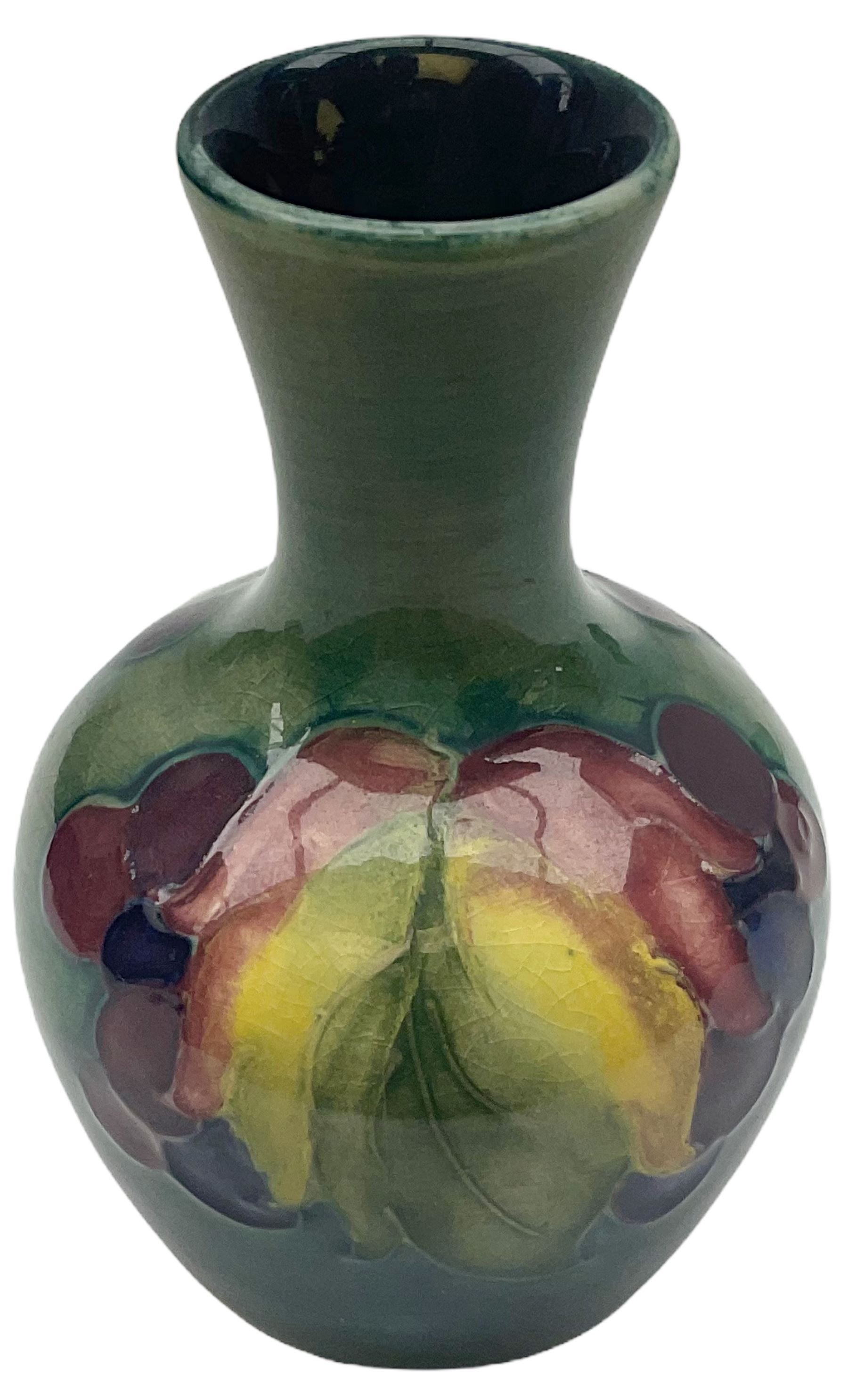 Moorcroft vase, decorated in the Leaf and Berries pattern upon a tonal green ground, together with a further Moorcroft vase, of squat baluster form, decorated in the Iris pattern upon a tonal green ground, each with impressed marks beneath, each H9cm. 