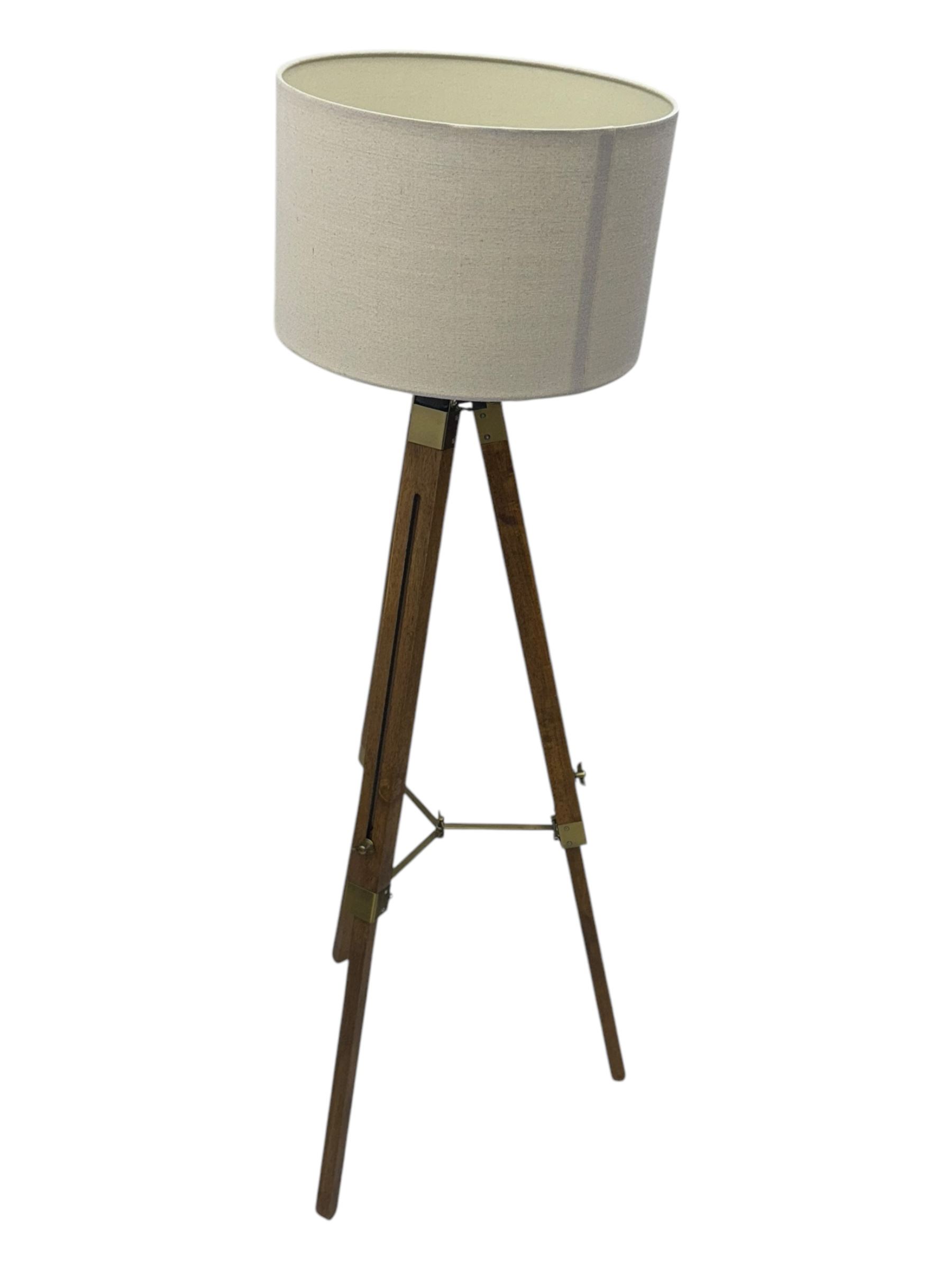 Wooden framed tripod standard lamp, with shade on adjustable legs with brass fititngs
