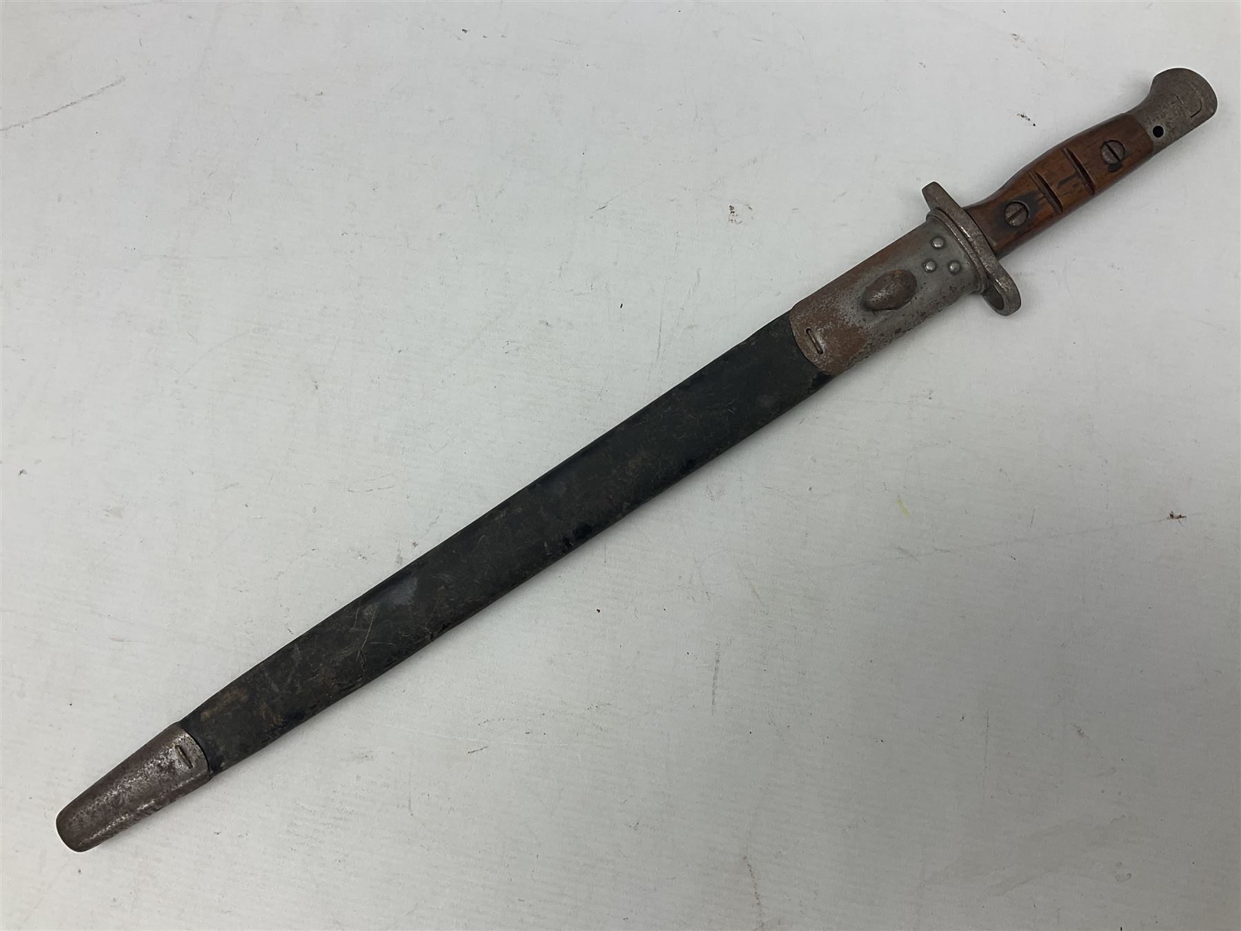 WW1 British 1907 pattern bayonet, the 43cm single edged fullered blade stamped to the ricasso with a crown GR cypher 1907 8 15 Sanderson, with various ordnance marks verso, two piece walnut grip, pommel stamped 1HLI 354; in steel mounted leather scabbard stamped 140 to the throat L57cm overall