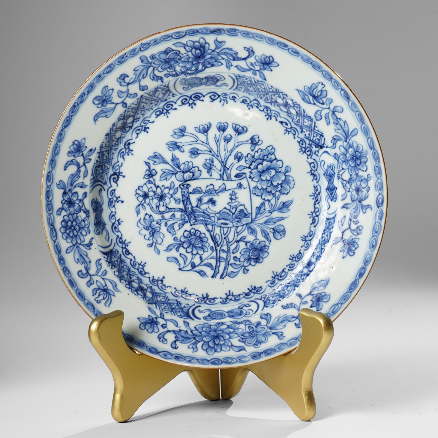 Pair of Chinese Kangxi period blue and white plates, painted in underglaze blue, decorated centrally with an unrolled handscroll revealing a shanshui landscape among foliage, D23cm (2)
