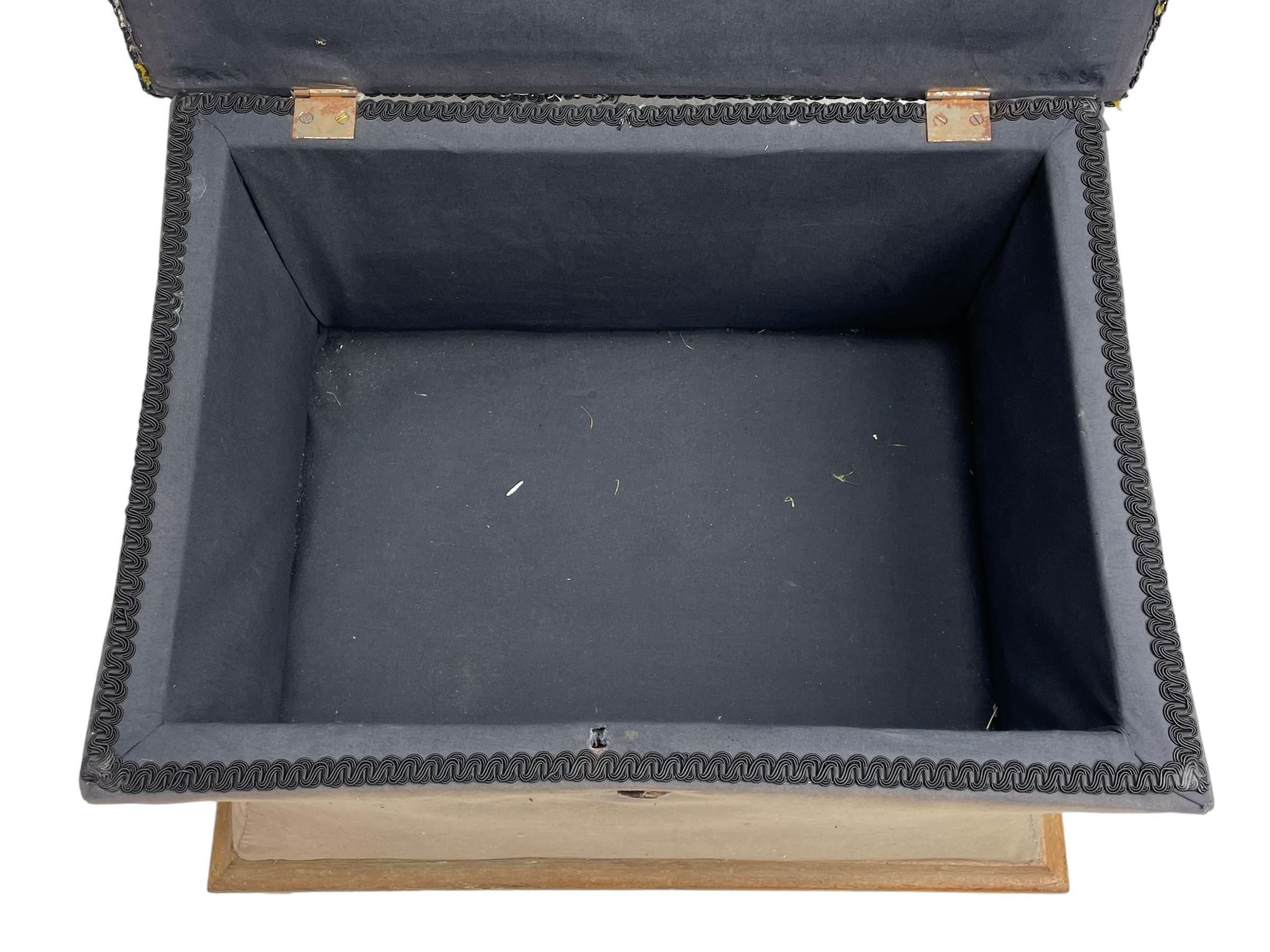 19th century upholstered ottoman, rectangular waisted form with hinged lid, upholstered in needle work cover decorated with floral panels and borders, the interior lined in blue fabric, lower moulded edge over compressed bun feet