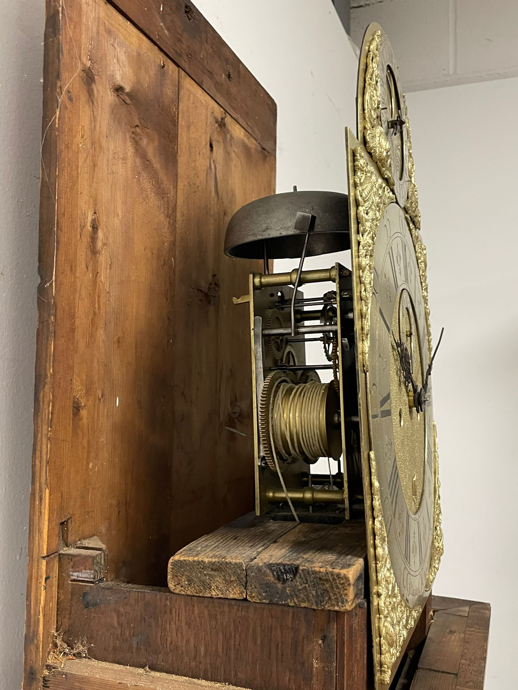 John Greaves of Newcastle - Mid-18th century 8-day oak longcase clock with a flat top, double cornice and break arch hood door flanked by two turned pilasters, trunk with canted corners and a spire topped door with crossbanding, rectangular plinth raised on bracket feet, brass dial with cast spandrels and penny-moon dial and pointer to the arch, matted dial centre with a silvered chapter ring and seconds ring, chapter with Roman numerals, five minute Arabic's, minute and quarter tracks, square date aperture and fettled steel hands, dial pinned to a rack striking movement with a recoil anchor escapement. With pendulum and weights.

