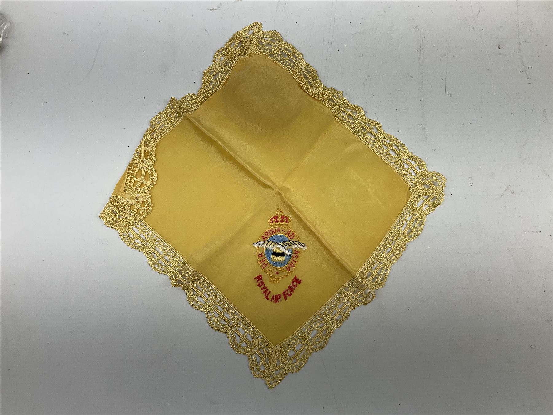 Three WW1 embroidered silk handkerchiefs including RAF & RN; trench art brass napkin ring inscribed 'Arras' and miniature peaked cap with inset 1914 penny; small quantity of cap badges and pips; four reference books on medals and badges etc