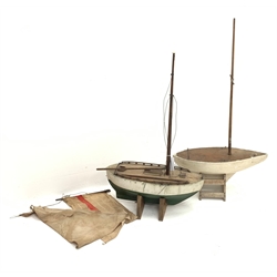 Two pond yachts - one with white and green painted wooden hull, weighted metal keel and simulated planked deck with hatches L46cm H72cm on wooden stand inset with enamelled Norwegian flag, the other with white painted wooden hull, weighted metal keel and plain wooden deck L46cm H77cm, on wooden stand (2)