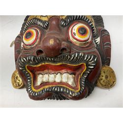 Four Balinese carved and painted wood dragon / demon masks, all with gilt decoration, largest L27cm