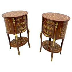 Pair of French design inlaid mahogany bedside lamp tables, oval form and fitted with three drawers, inlaid throughout with scrolling leafy branches, on cabriole supports united by undertier, decorated with floral cast gilt metal mounts 