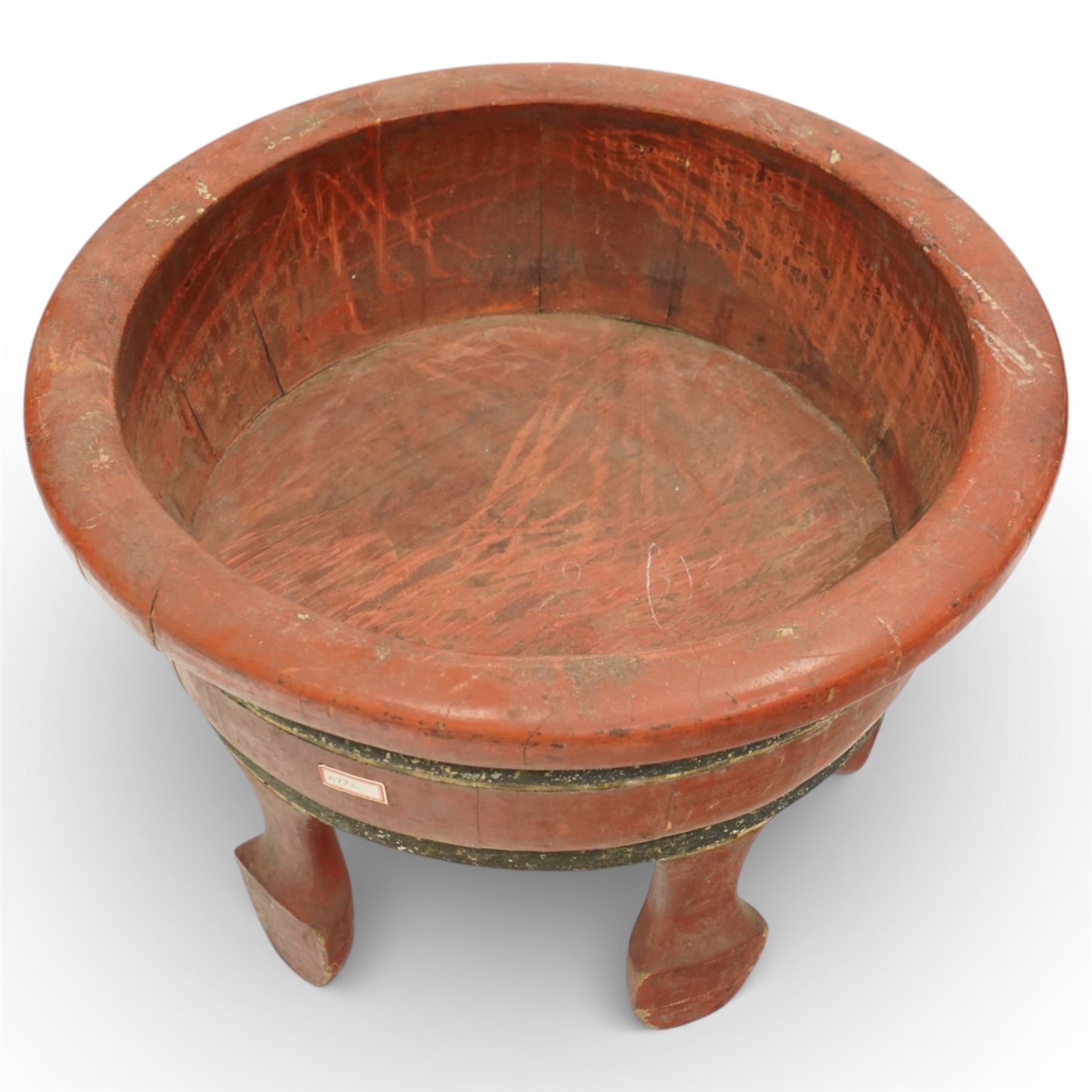 Chinese red painted wooden wash bowl, of circular form with a thickened rim above a tapering body with painted bands, raised on five short supports
