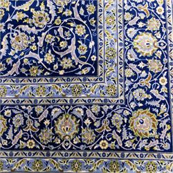 Central Persian Kashan hand-knotted carpet, deep indigo blue field densely decorated with all-over vine, palmette and flowering sprays arranged in a symmetrical pattern enclosed by broad navy border of stylized palmettes, and foliate vine decoration between multiple guard stripes, with cotton fringe ends 