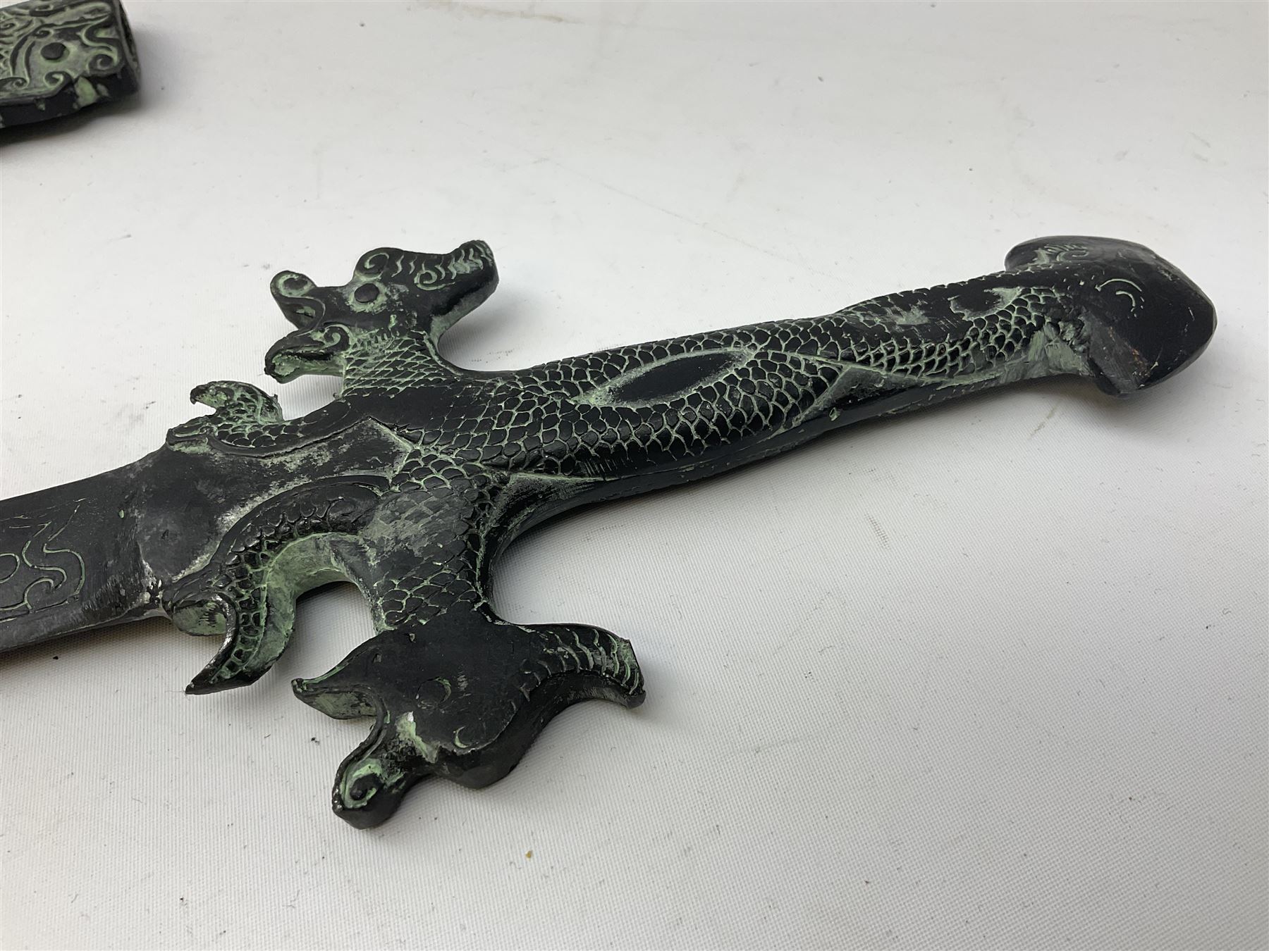 Patinated 'bronze' fantasy dagger, the 26cm blade, hilt and scabbard cast with dragons L50cm overall; hand forged iron spearhead L29.5cm; and a stiletto blade (3)