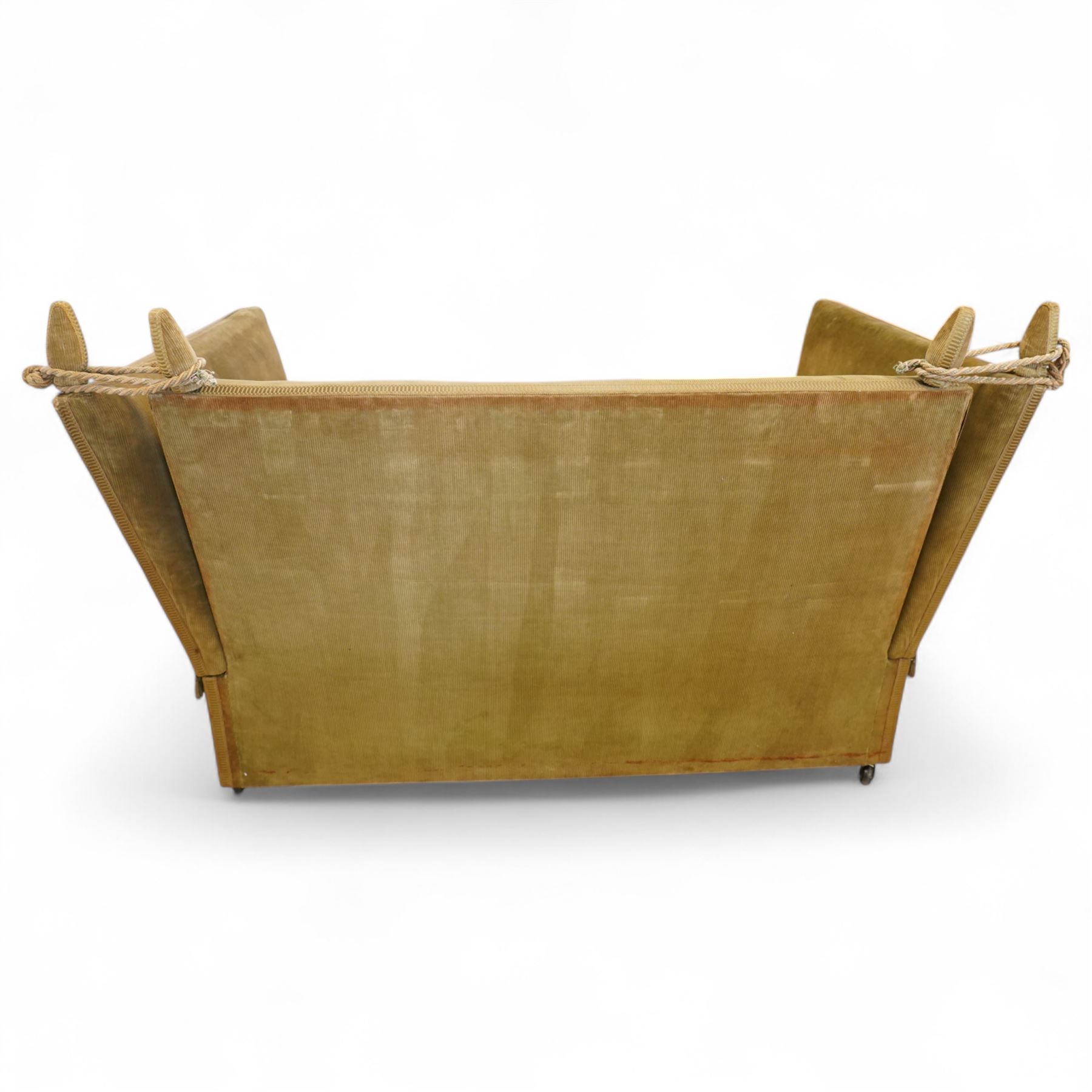 Mid-20th century Knoll style high back sofa, upholstered in olive green velvet with tassel fringe trim, sloped hinged arms and twin loose seat cushions, the frame surmounted by four finials