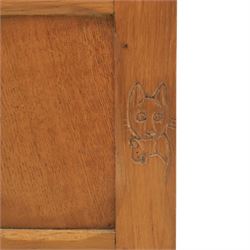 Cat & Mouseman - oak corner cabinet, glazed door with two fixed glass shelves, above a panelled door and sides raised on a plinth base, with cat and mouse carving to the lower side by Lyndon Hammell a former apprentice of Robert 'Mouseman' Thompson