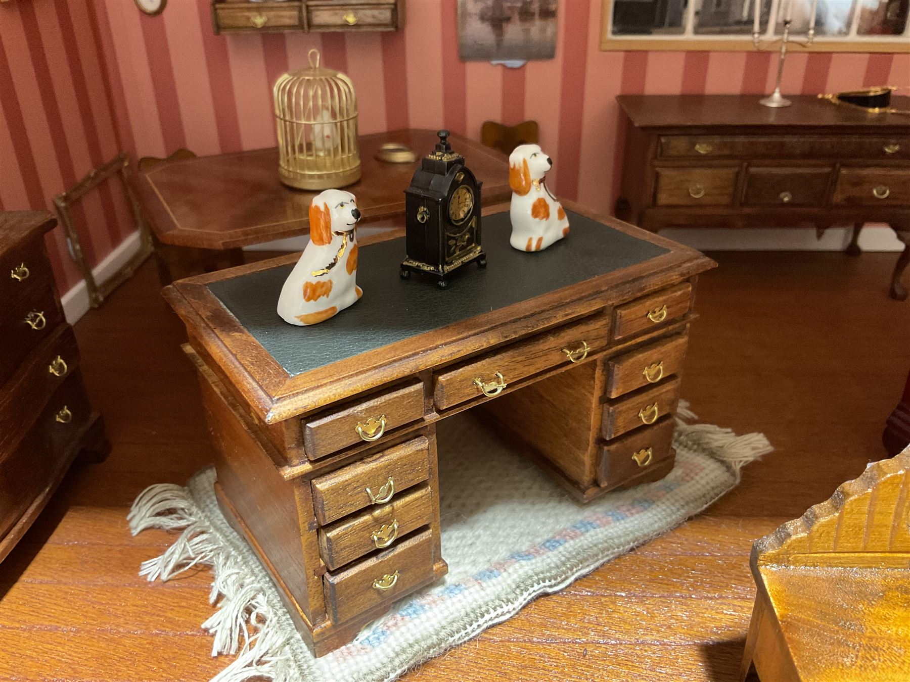 Good quality late 20th century dolls house by M. James dated 1995 in the form of a Beverley East Yorkshire Antique Shop called 'North Bar Antiques'; single-storey single-roomed shop with textured brick walls and flat roof, fully glazed hinged front with recessed hinged customer door and central window to the rear; comprehensively furnished with chests of drawers, pedestal desk, breakfast table, lowboy, two longcase clocks, delft rack with ceramics, occasional tables, pictures, Regency style mirror and collectibles; decorated walls with coving and picture rail and simulated floorboarding; wired for electric lighting; maker's plaque W61cm H42.5cm D41.5cm