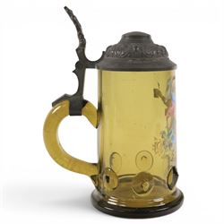 19th century German green glass stein, enamel decorated with a gentleman holding a stein, with a pewter lid, together with another smaller example decorated with a coat of arms 