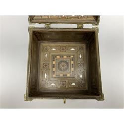 Late 19th century Damascus Cairoware Quran box, of square form with canted hinged cover, upon four circular pad feet, the brass exterior inlaid with silver and copper script and decorative detail, opening to reveal a marquetry lined interior, H15.5cm W19cm D19cm