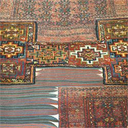 Central Asian vintage saddle cover, probably Turkmen, wool pile and flatweave on wool foundation, decorated with geometric tribal motifs in a palette of madder red, indigo, ivory, and dark brown, with cotton fringe ends 