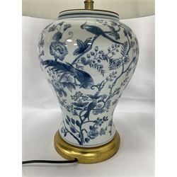 Pair of blue and white table lamps, each of baluster form, decorated with exotic birds, raised upon circular gilt bases, excluding fittings H39cm