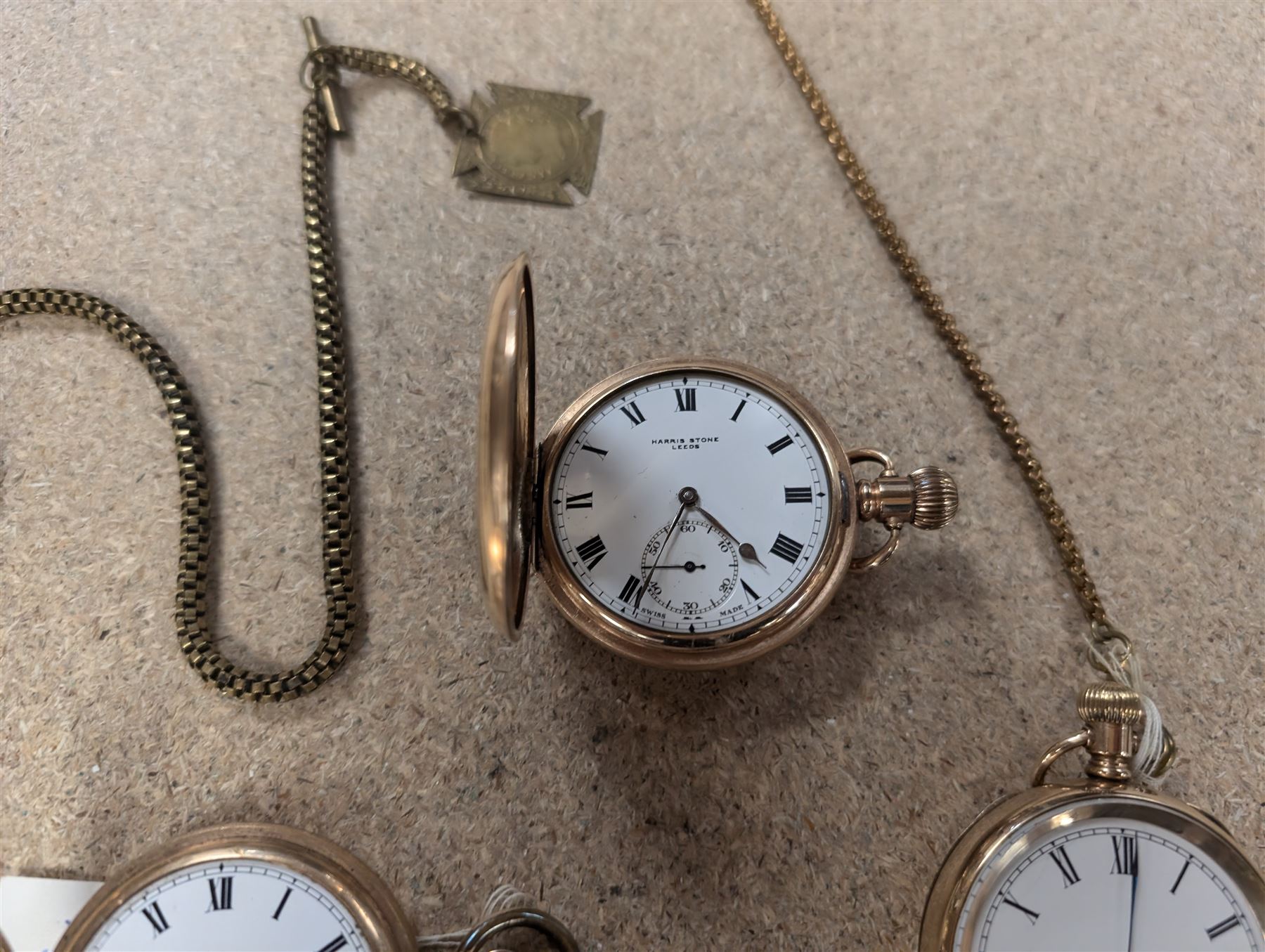 Four early 20th century gold-plated keyless pocket watches, three by Harris Stone Leeds, Waltham and Elgin and two gold-plated watch chains
