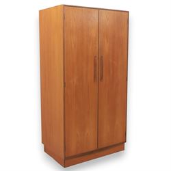 G Plan - 'Fresco' teak double wardrobe, twin doors enclosing a single clothes rail, on a r...